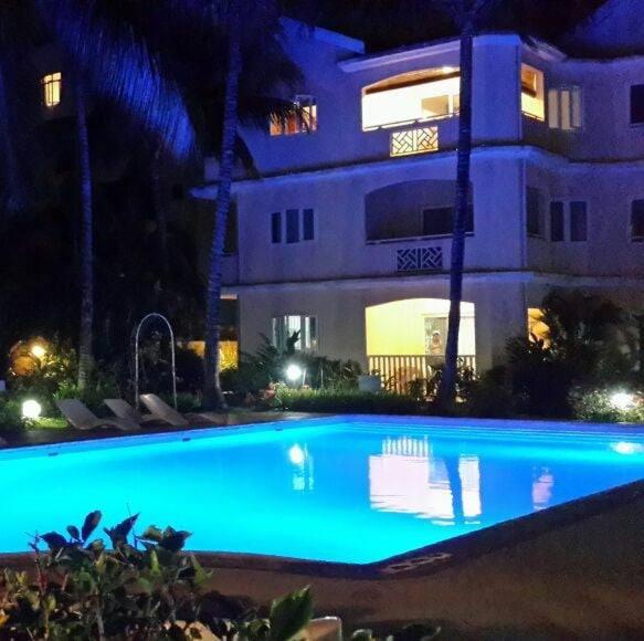 una piscina frente a un edificio por la noche en Residence Le Palmier, en Flic en Flac