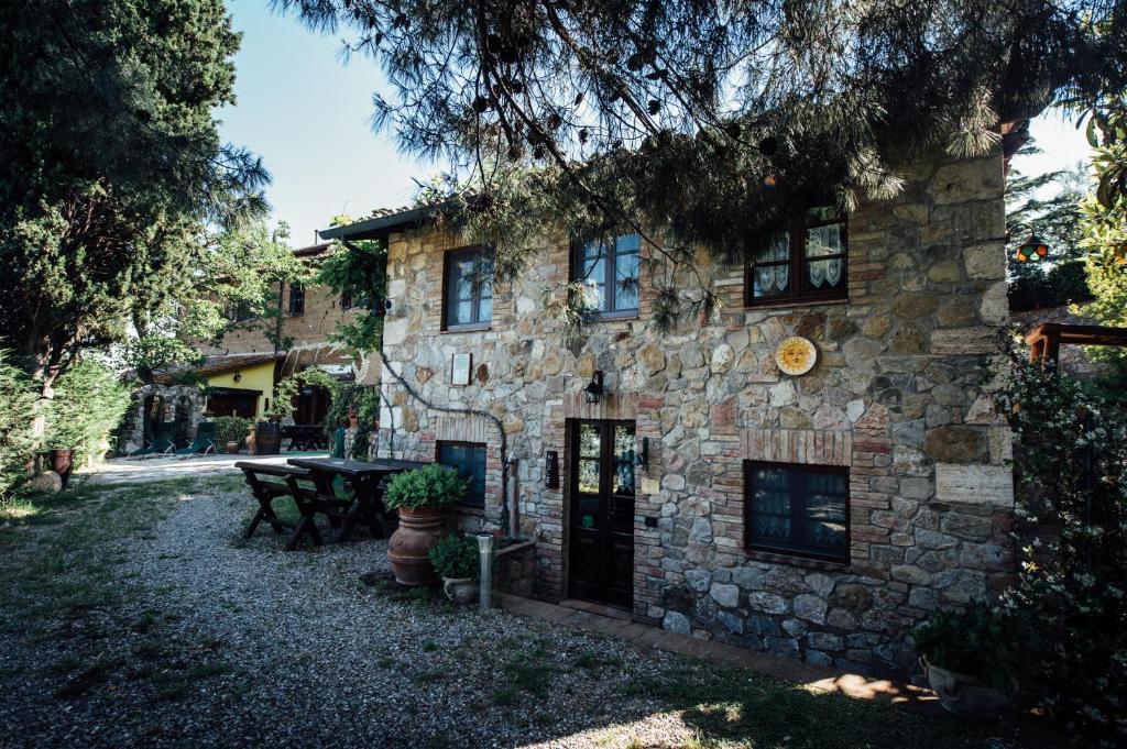 una casa in pietra con un tavolo da picnic di fronte di Agriturismo il Noce a Castiglione dʼOrcia