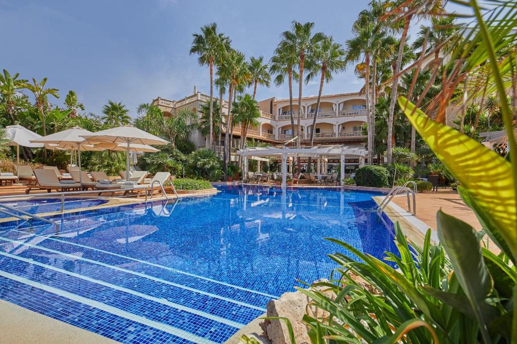 basen w ośrodku z leżakami i parasolami w obiekcie Boutiquehotel El Coto w miejscowości Colonia Sant Jordi