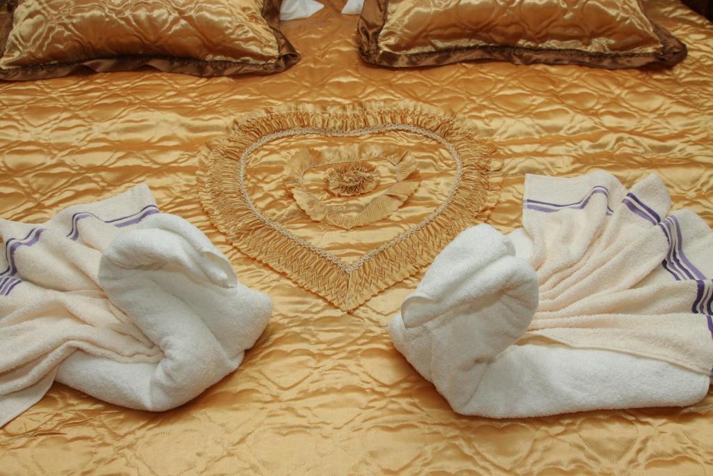 a bed with towels and a heart on it at Apartman ŠOKICA in Bizovac