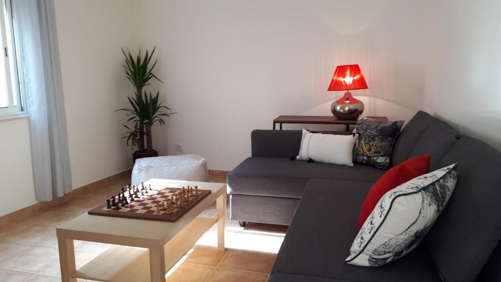 Crisapartment في لشبونة: غرفة معيشة مع أريكة وطاولة شطرنج