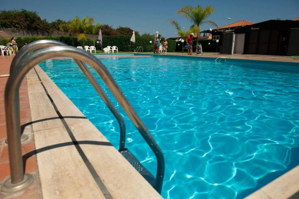 a large blue swimming pool with a metal hand rail at Casa Aurelia in Mascali