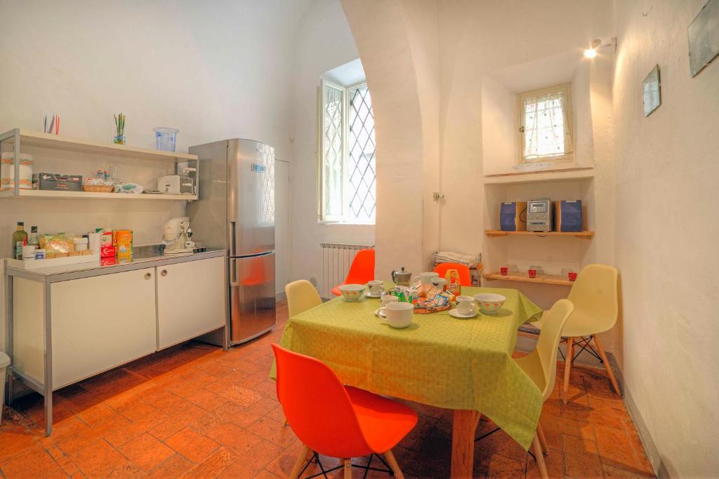 une cuisine avec une table avec des chaises et un réfrigérateur dans l'établissement Stilmoderno Nice Apartment in Siena's Historic Center, Just Steps from Piazza del Campo, à Sienne
