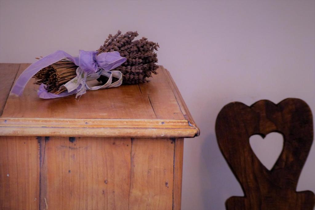 une boîte en bois avec une étrave violette et quelques cônes de pin dans l'établissement Limonetto dream, à Limone Piemonte