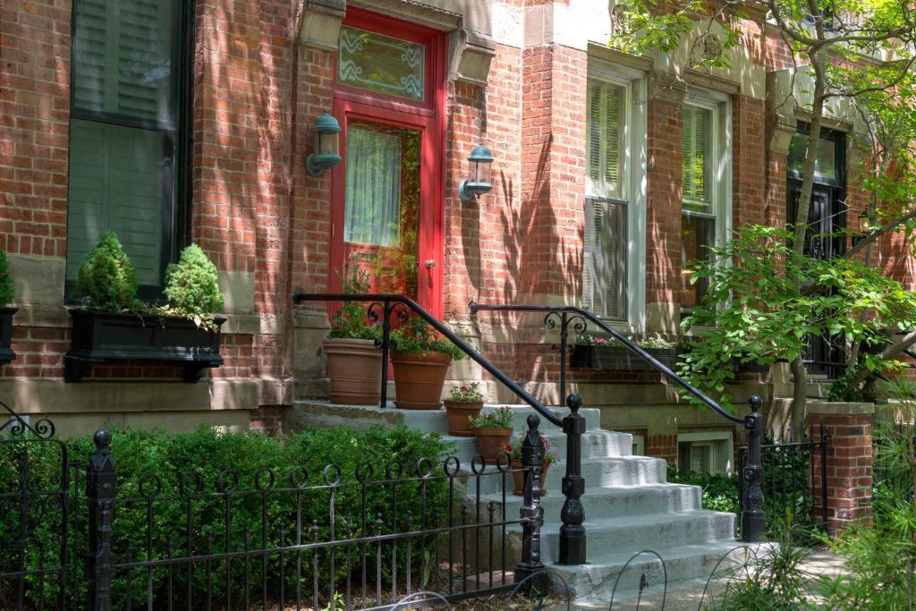 a house with a red door and stairs with potted plants at webster house in Chicago