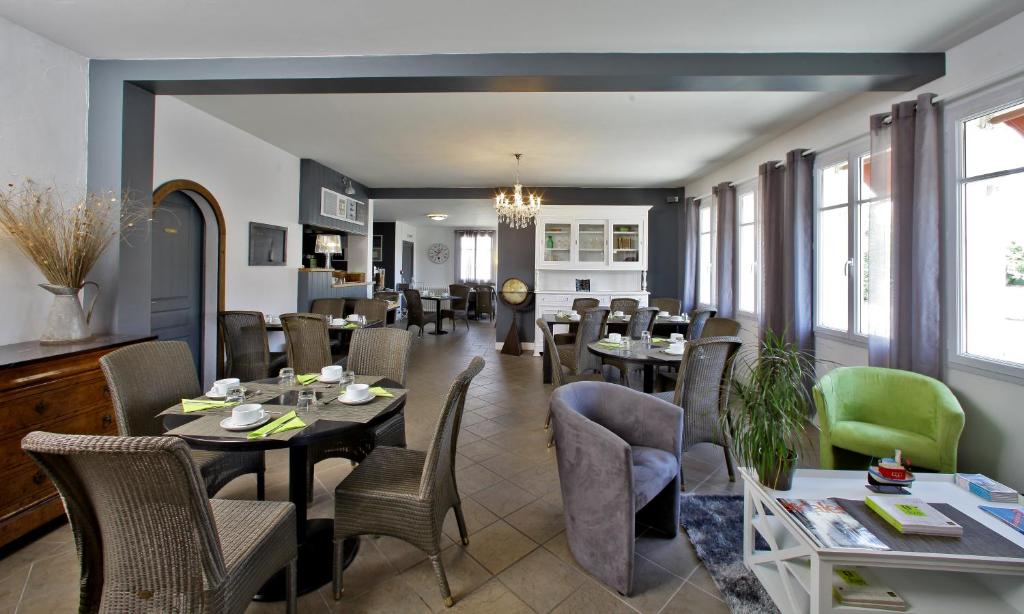 a dining room with tables and chairs and windows at Logis Hôtel La Chaize in Noirmoutier-en-l'lle