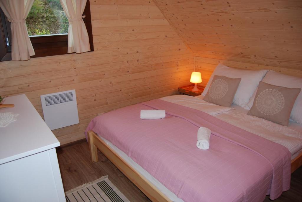 Un dormitorio con una cama en una cabaña de madera. en Chata Marta, en Oščadnica