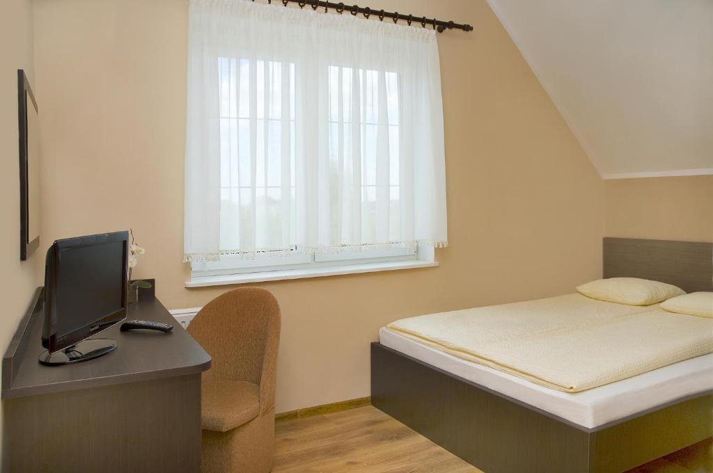1 dormitorio con 1 cama y escritorio con ordenador en Sand Residence - Pokoje i Apartamenty, en Władysławowo