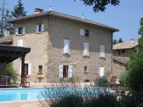 un grande edificio in mattoni con una piscina di fronte di Le Lavoir de Meziat a Vinzelles