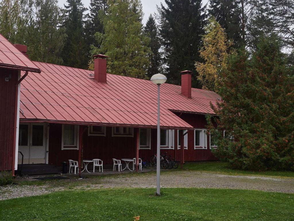 ein rotes Haus mit rotem Dach und Straßenbeleuchtung in der Unterkunft Hostel Pielinen in Vuonislahti