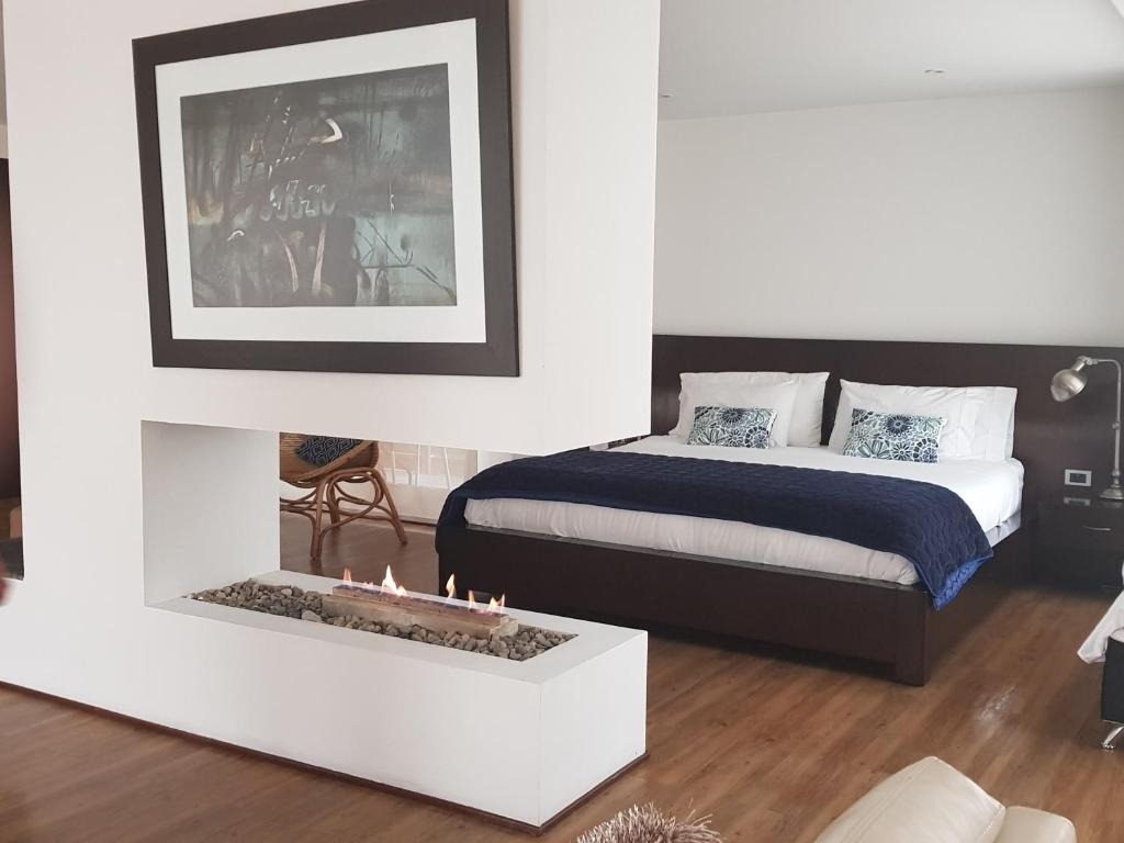 a bedroom with a bed and a fireplace at Suites Casa 95 in Bogotá