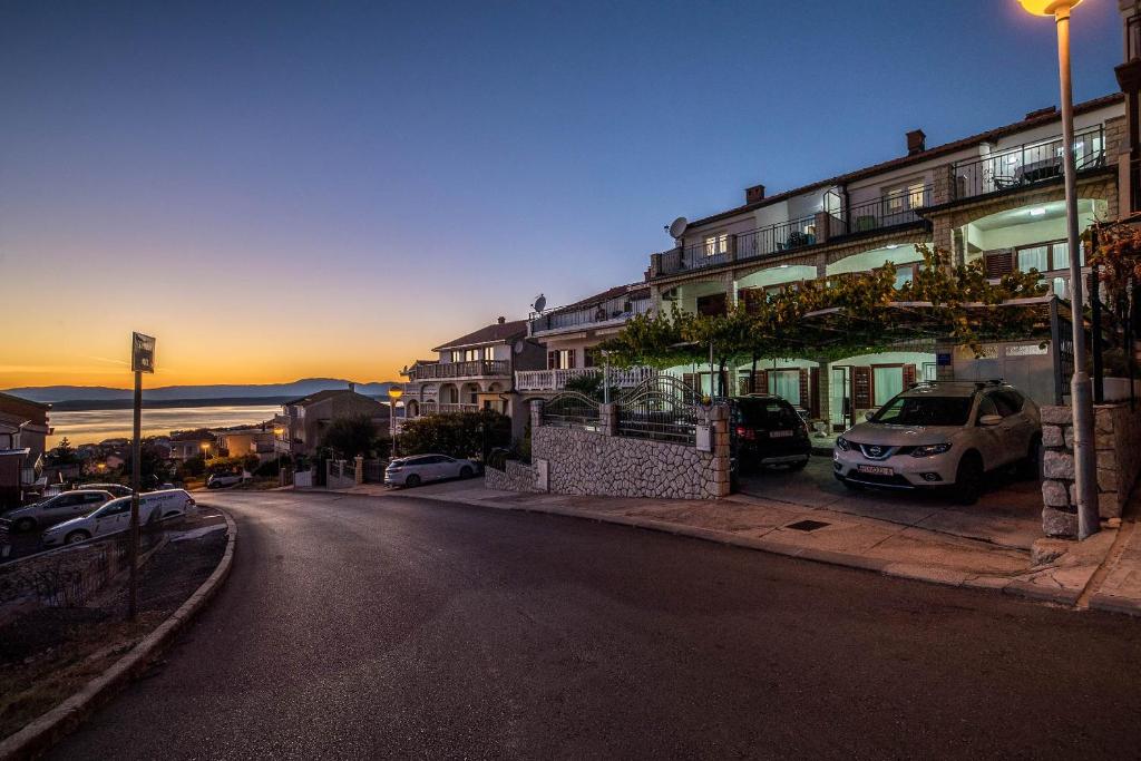 a city street with cars parked in front of buildings at Apartments Baretić in Crikvenica
