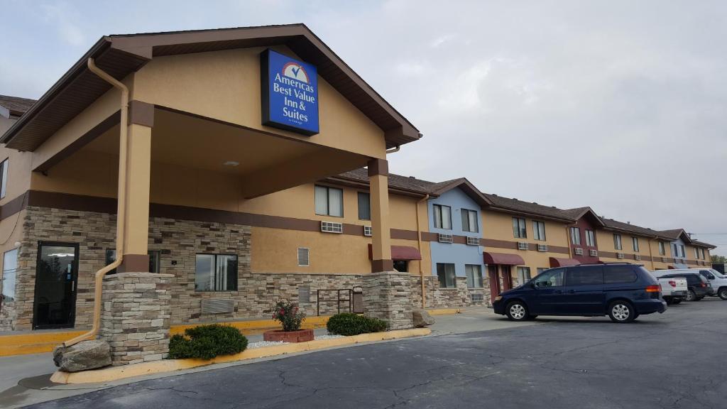 ein Hotel mit einem Auto auf einem Parkplatz in der Unterkunft Americas Best Value Inn & Suites Harrisonville in Harrisonville
