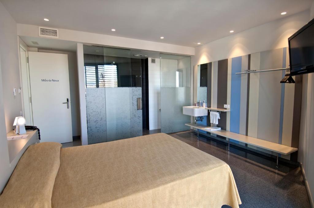 1 dormitorio con 1 cama grande y lavamanos en Hostal La Creu, en Móra d'Ebre