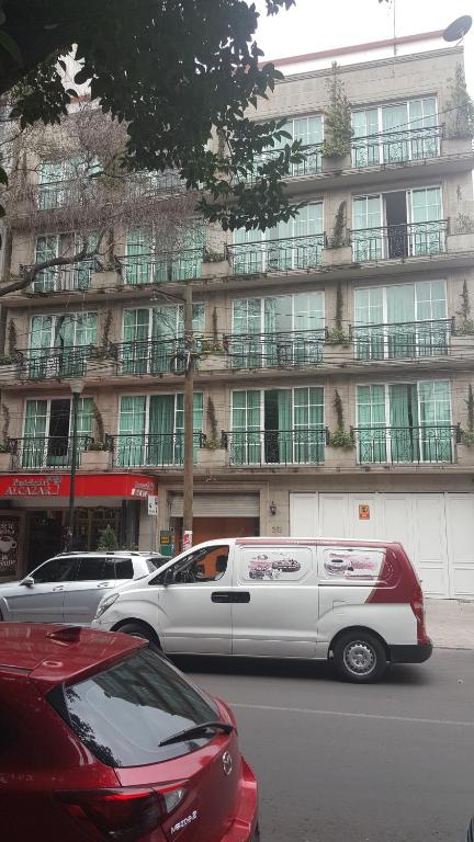 una limusina blanca estacionada frente a un edificio en Suites Lerma 202, en Ciudad de México