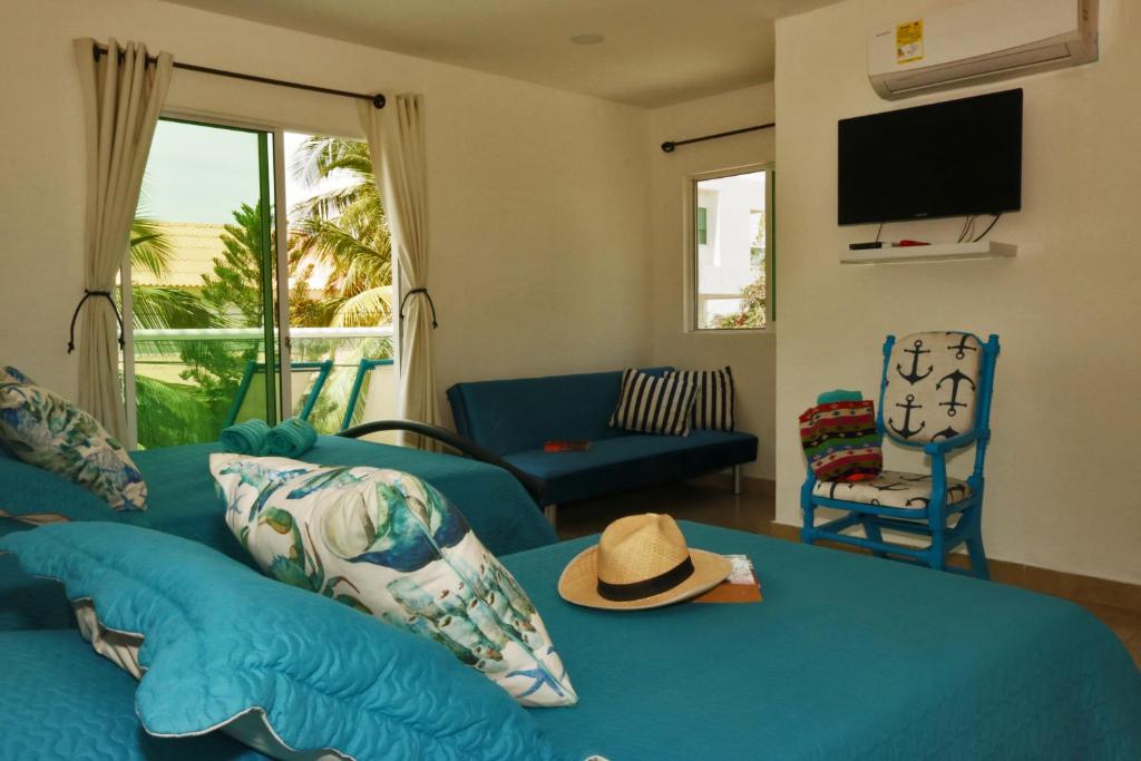a living room with a blue couch with a hat on it at Casa de Mony in Santa Marta