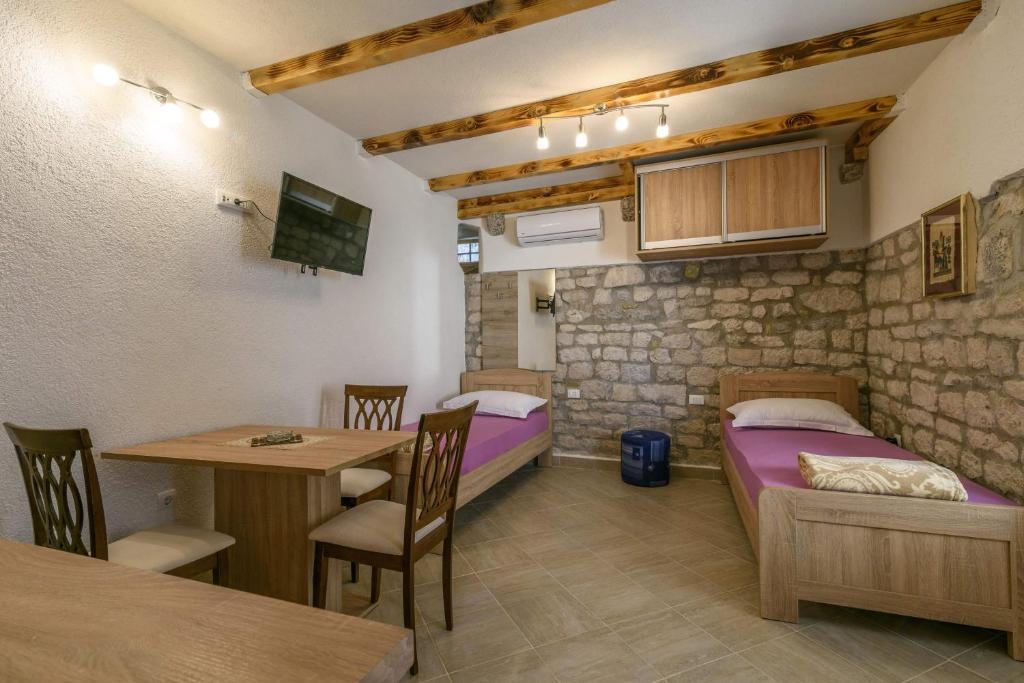 een kamer met een bed en een tafel en stoelen bij Lorena in Trogir