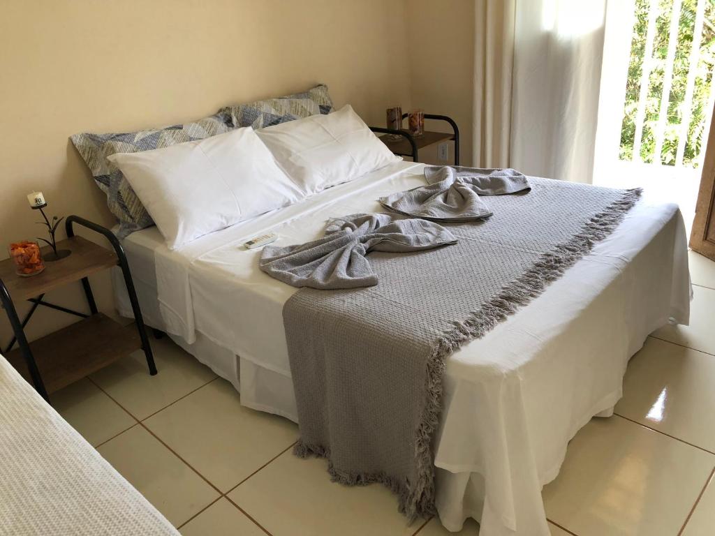 Una gran cama blanca con toallas encima. en Village Funchal 01, en Lençóis