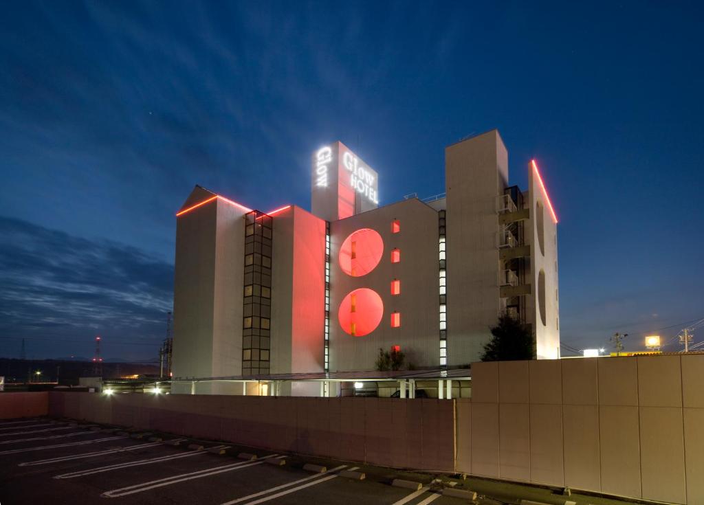 a large building with a clock on it at night at Hotel Glow Yokkaichi (Adult Only) in Yokkaichi