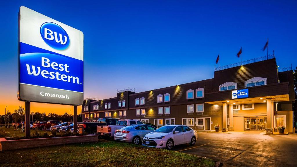 un edificio con coches estacionados en un estacionamiento en Best Western Thunder Bay Crossroads, en Thunder Bay