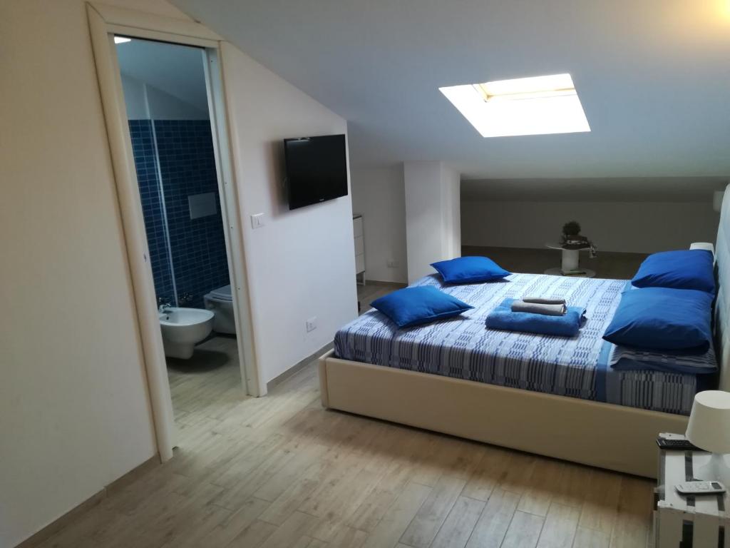 モンテジルヴァーノにあるAttic Designのベッドルーム(青い枕とテレビ付)