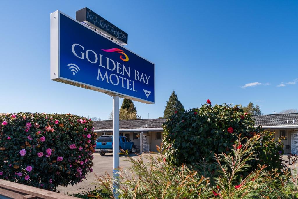 um sinal azul para um motel Garden Bay em Golden Bay Motel em Takaka
