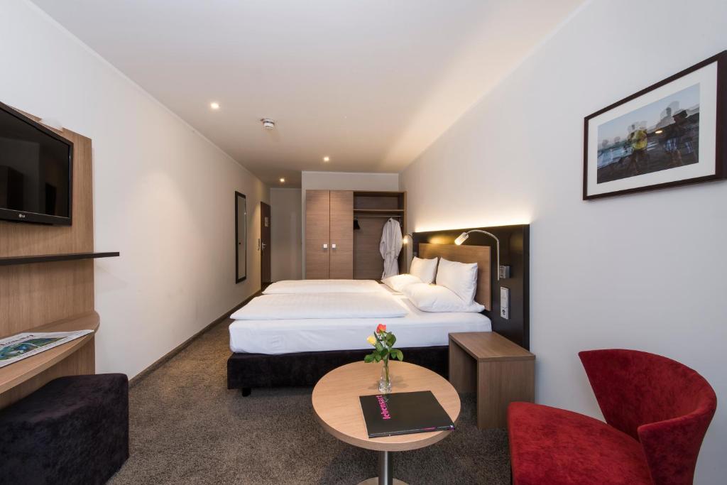 ein Hotelzimmer mit einem Bett und einem TV in der Unterkunft Astor & Aparthotel in Köln