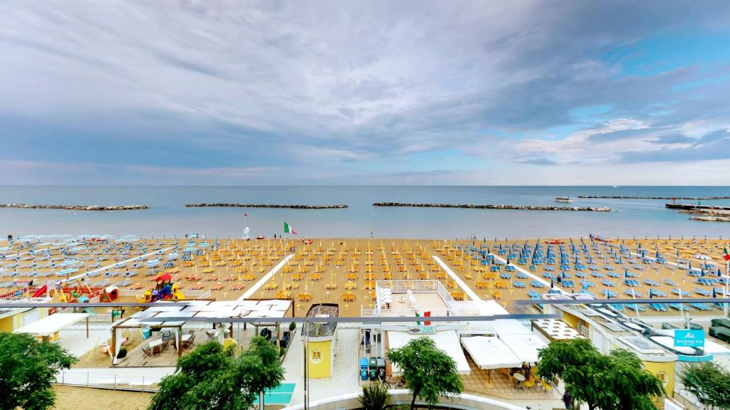 a beach with a lot of umbrellas and the ocean at Bell Suite Hotel in Bellaria-Igea Marina