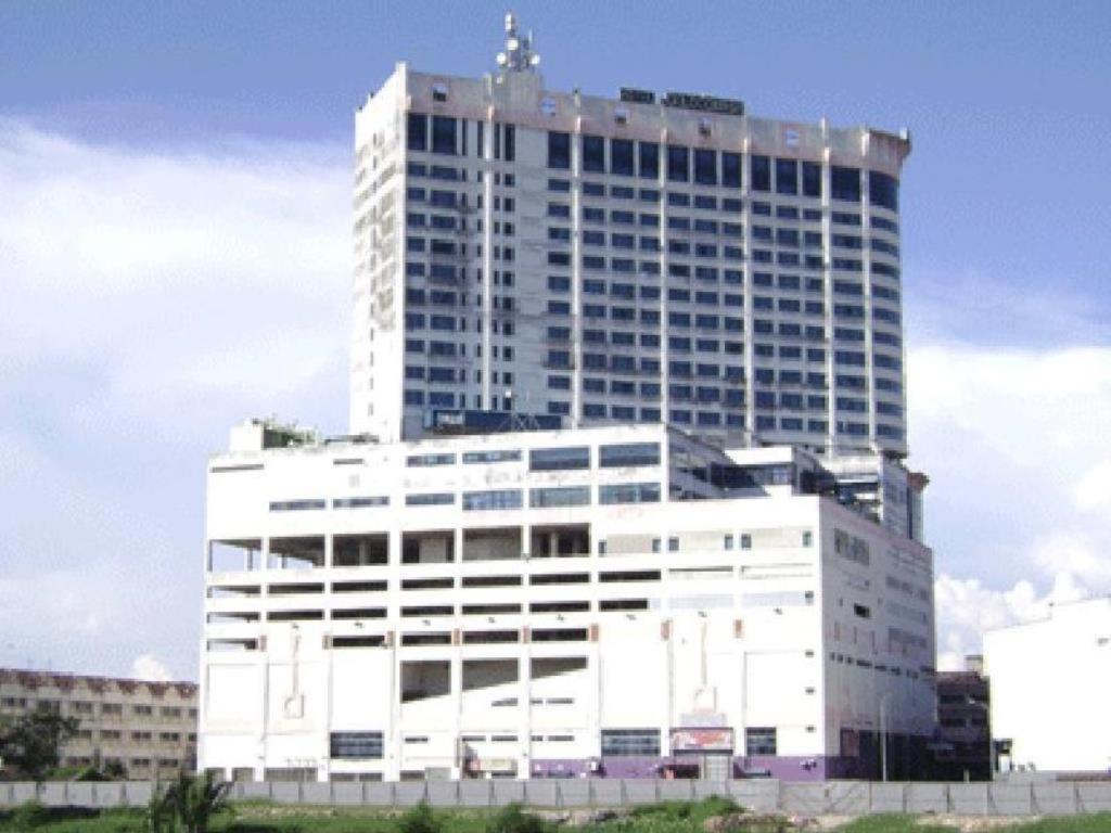 ein großes weißes Gebäude mit einem Kreuz darüber in der Unterkunft GOCOS Hotel in Klang