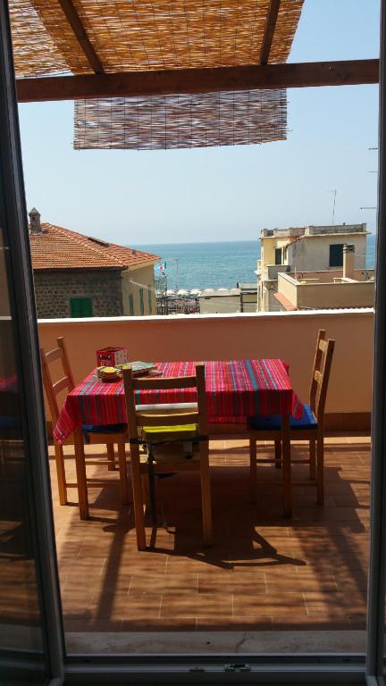 a table and chairs on a balcony with a view of the ocean at Casa Vacanze Ladispoli in Ladispoli