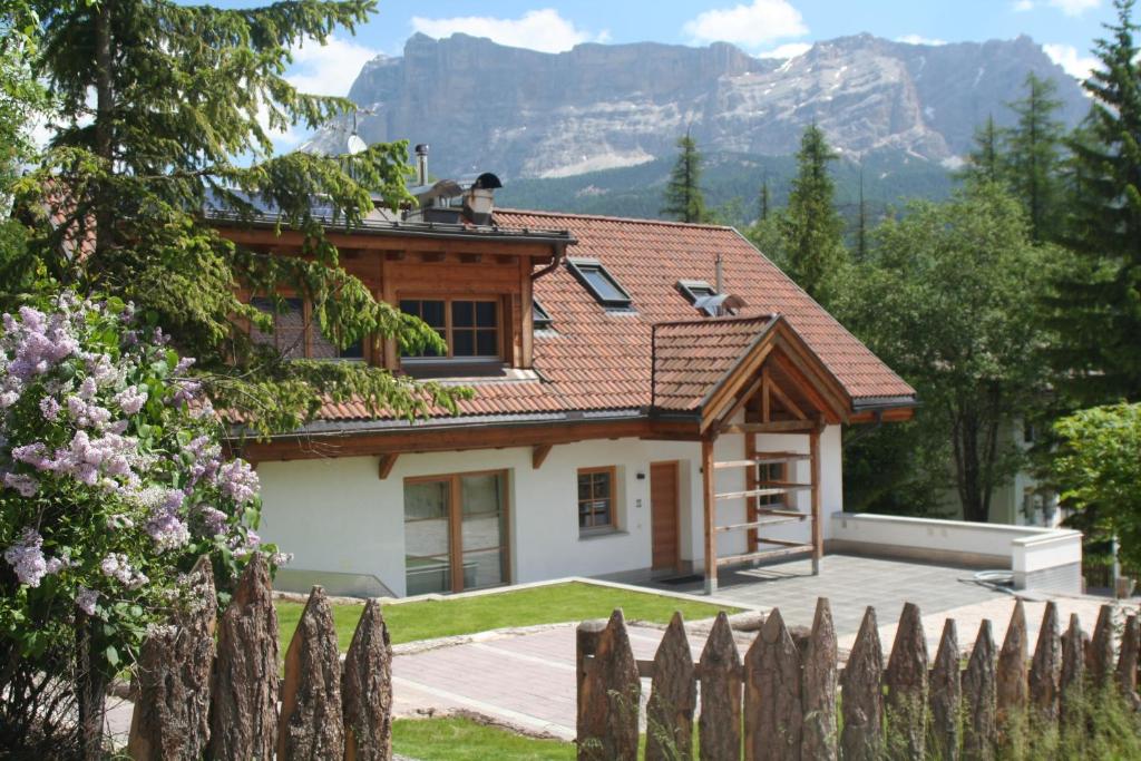 una casa en las montañas con una valla en Casa Zilli, en La Villa