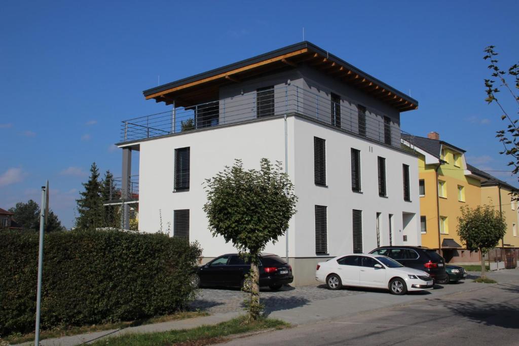 een wit gebouw met auto's ervoor geparkeerd bij ANICO apartmány in Dolní Benešov