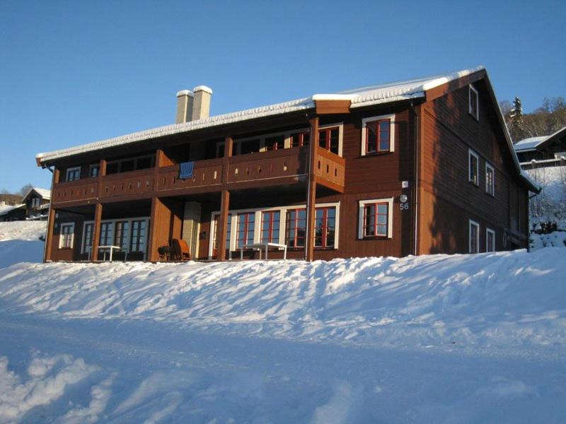 un grand bâtiment dans la neige devant dans l'établissement Hafjell Grenda lejligheder, à Hafjell