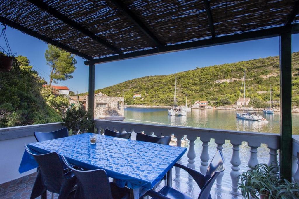 a table on a balcony with a view of a river at Holiday House Macić in Vis