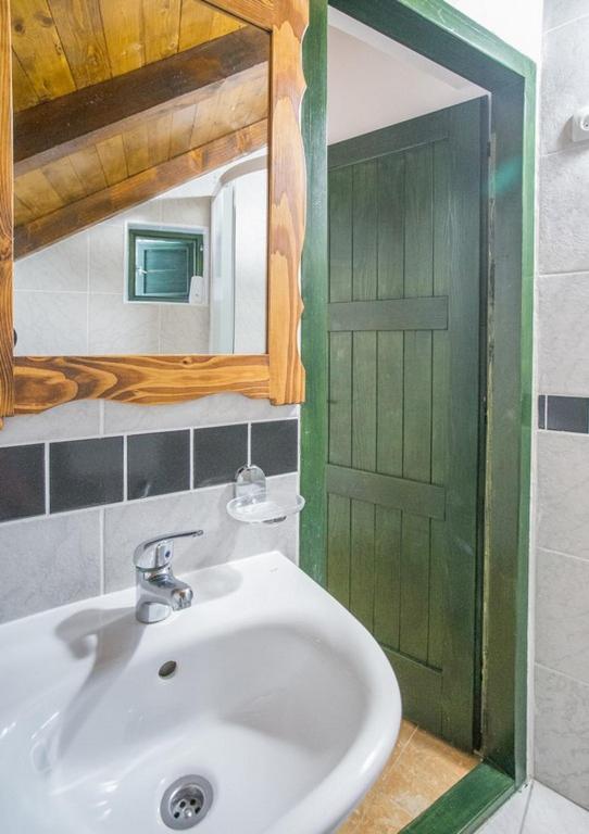 a bathroom with a sink and a green door at Holiday House Macić in Vis