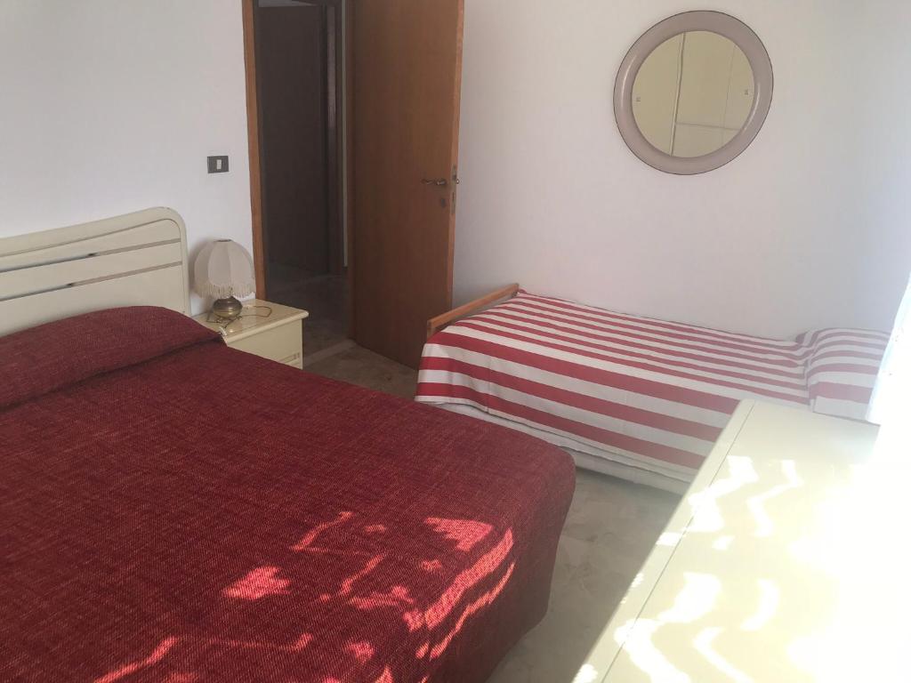 マロッタにあるMarotta Charminghouseのベッドルーム(赤いベッド1台、鏡付)
