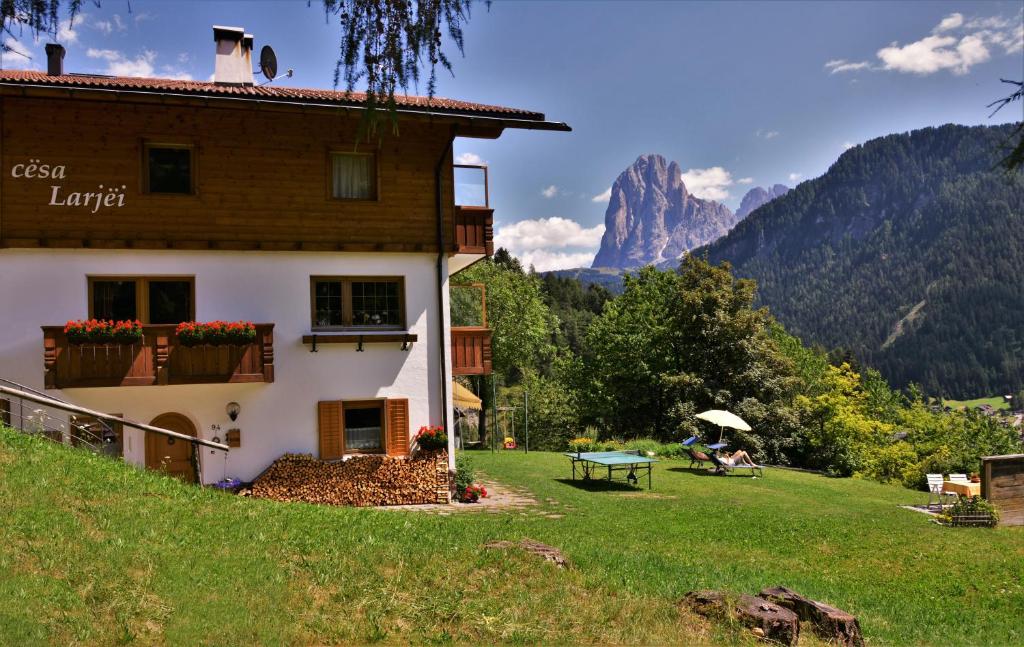a house on a hill with a mountain in the background at Apartment Larjëi in Ortisei