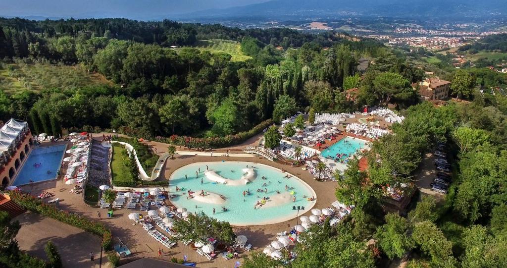 uitzicht op een groot zwembad in een resort bij hu Norcenni Girasole village in Figline Valdarno