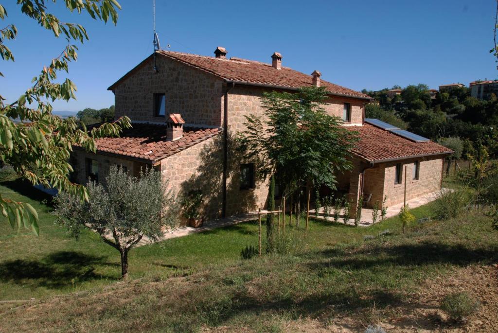 an old stone house on a hill in a field at Residenza al Poggio degli Ulivi in Montepulciano