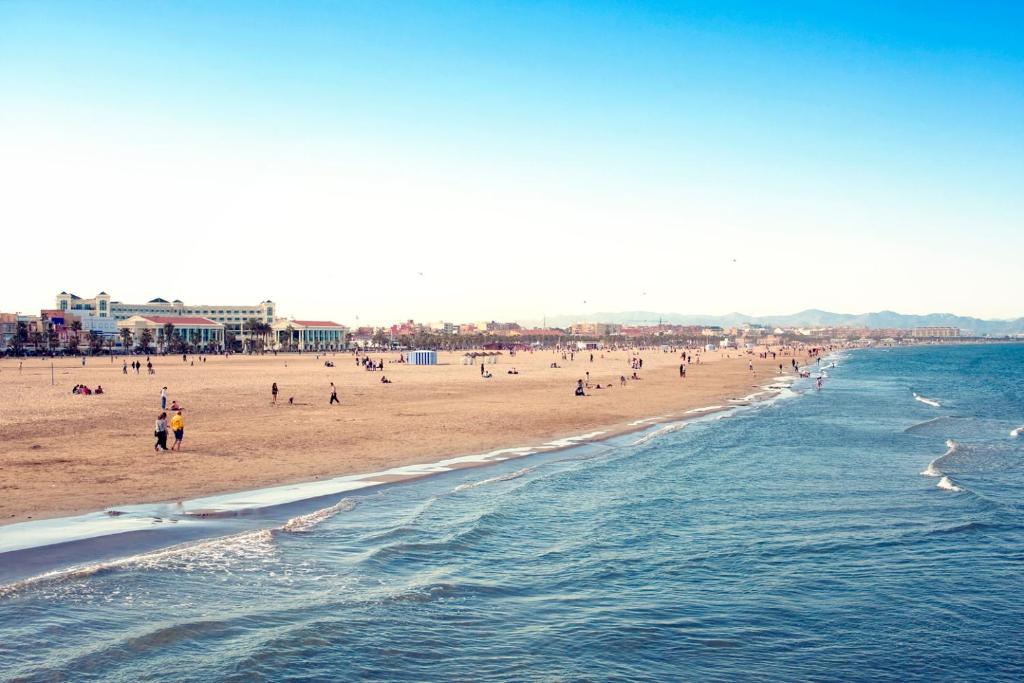 a group of people on a beach with the ocean at Aparthotel Albufera in Alfafar