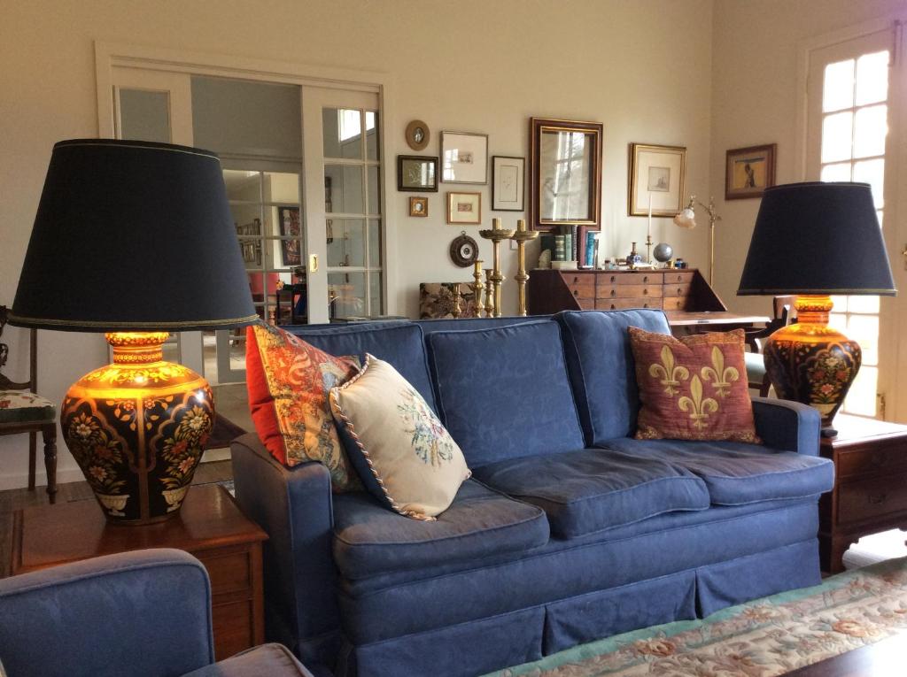 a blue couch in a living room with two lamps at Hollyoak in Trentham