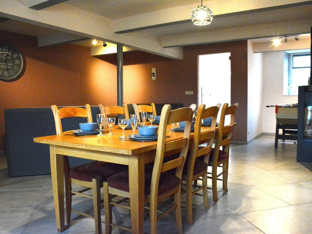 - une table en bois avec des chaises et des verres à vin dans l'établissement Vintage Holiday Home in Couvin near River, à Aublain