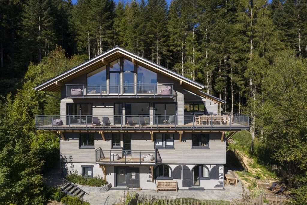 a large house with a large balcony and trees at Schweizerhaus in Alpirsbach