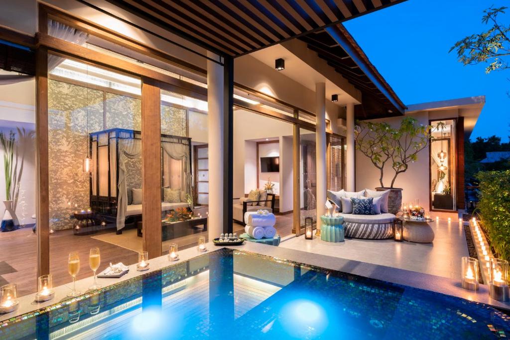 a swimming pool in a villa with a patio at The Sarojin in Khao Lak