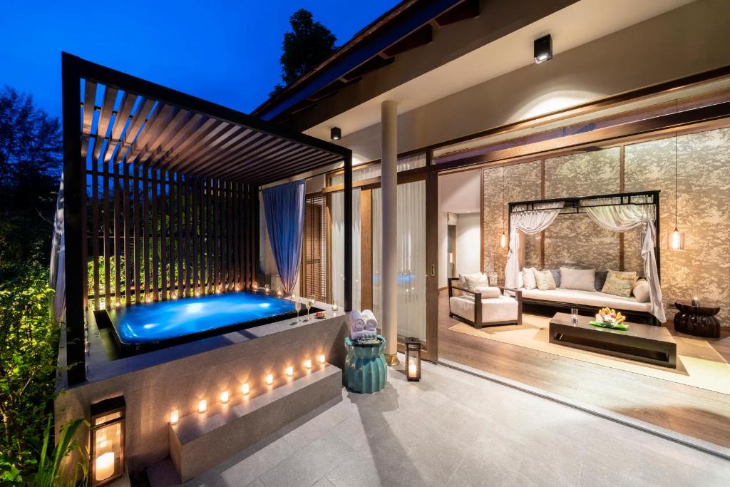 a backyard with a hot tub and a living room at The Sarojin in Khao Lak