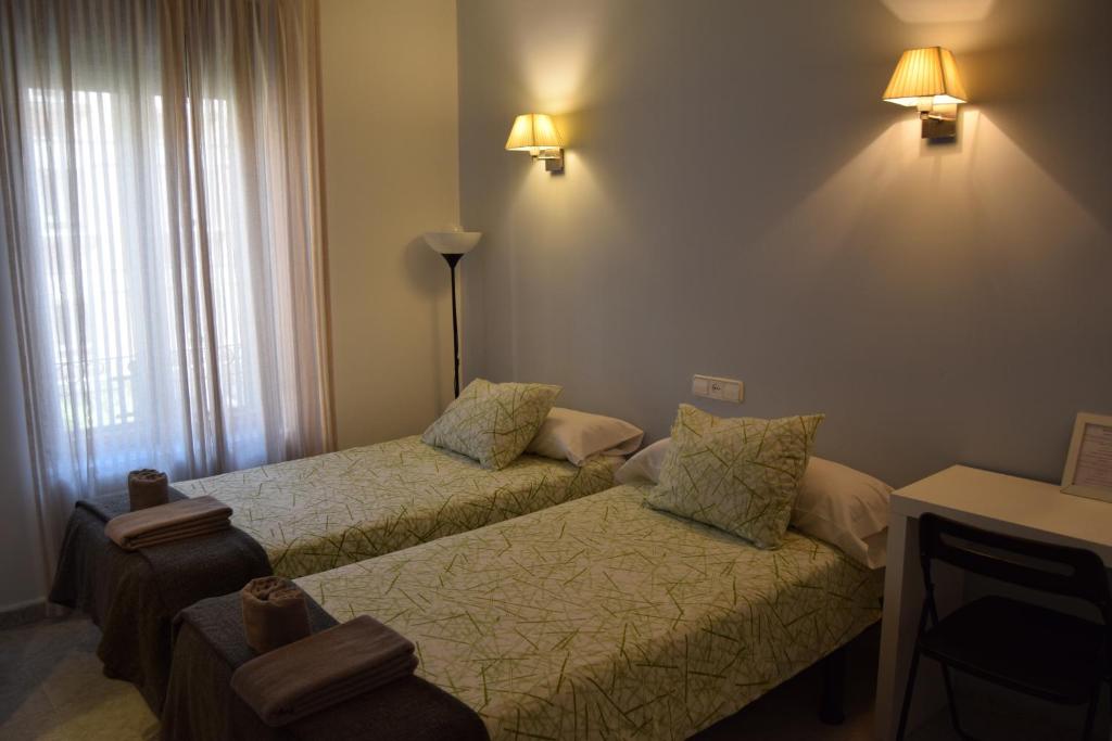 una habitación de hotel con 2 camas y una lámpara en Hostal Rofer, en Madrid