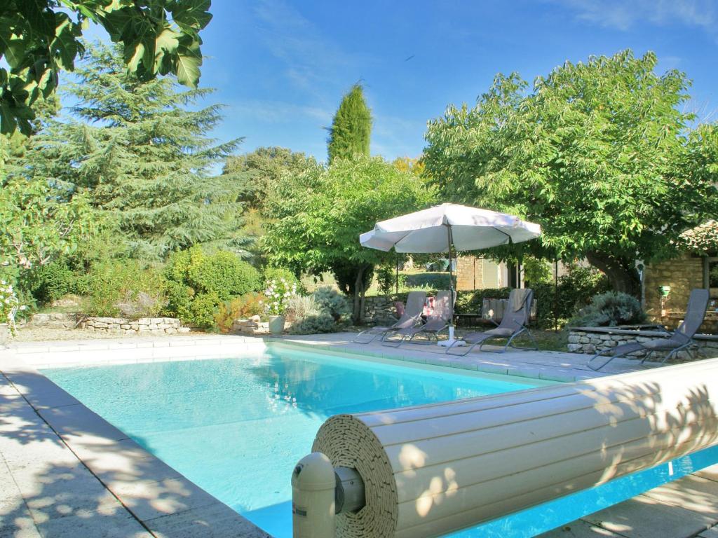 ViensにあるStylish villa with private pool in the middle of a village in the beautiful Luberonのパラソルと椅子付きのスイミングプール