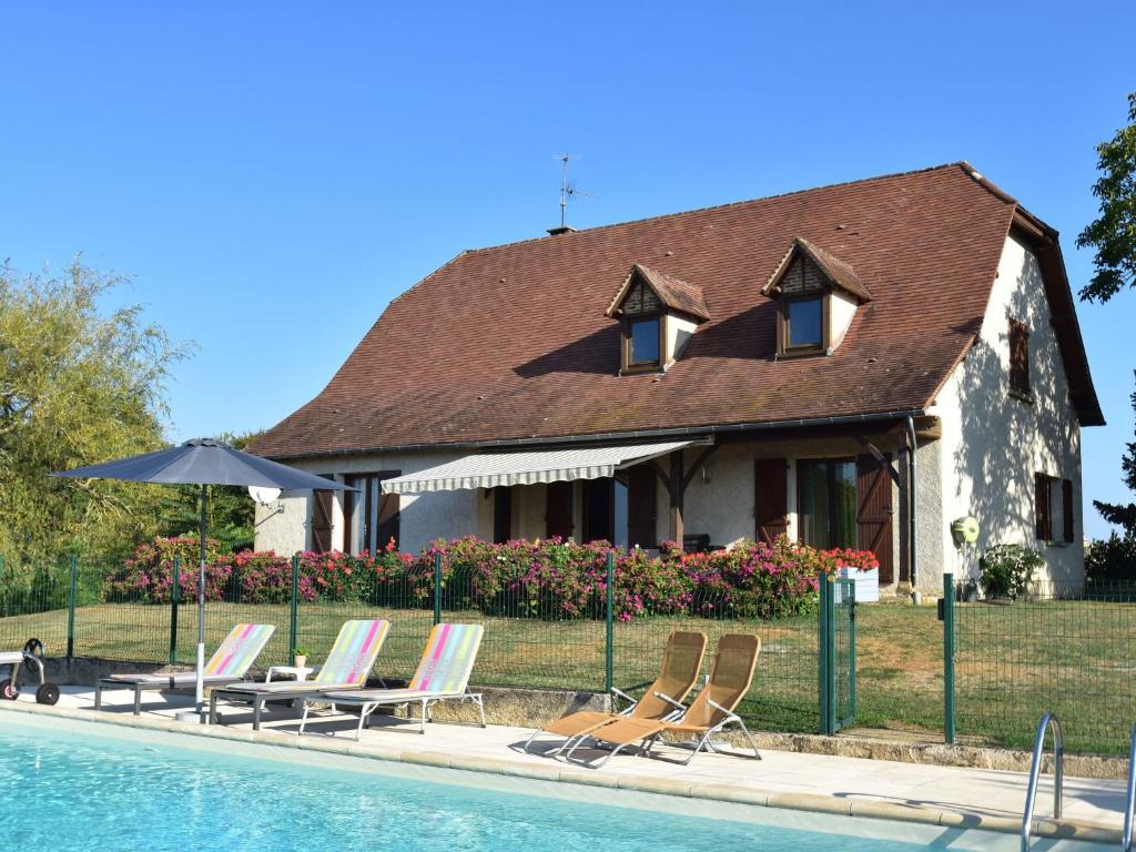 a house with lounge chairs and a swimming pool at Comfy villa near Alvignac with private pool in Alvignac