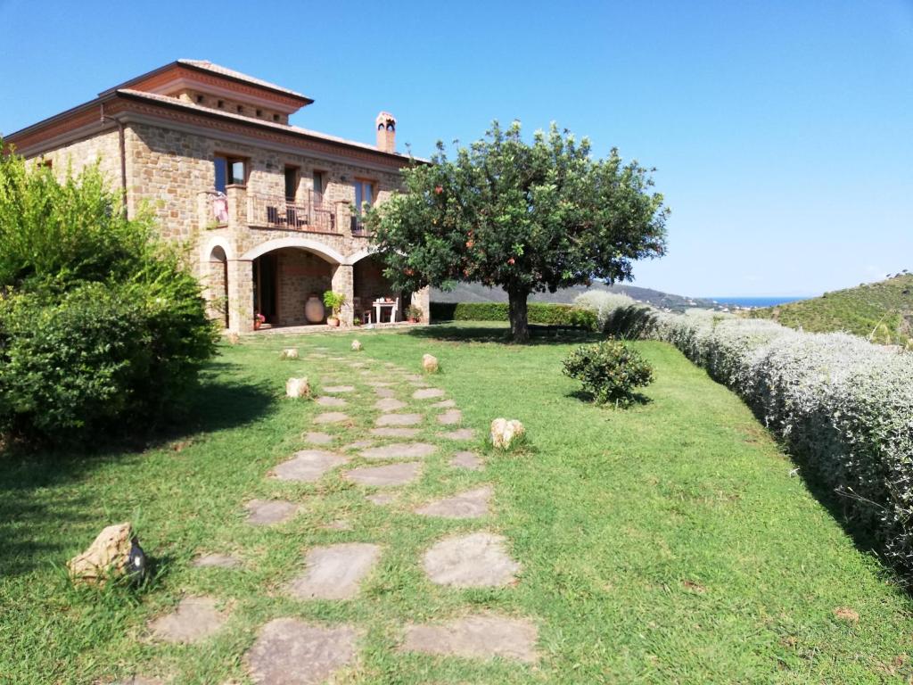 un camino de piedra frente a un edificio con un árbol en Sulle Onde Della Collina, en Montecorice