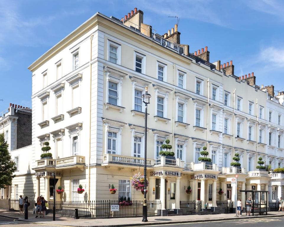 ein großes weißes Gebäude in einer Stadtstraße in der Unterkunft Sidney Hotel London-Victoria in London